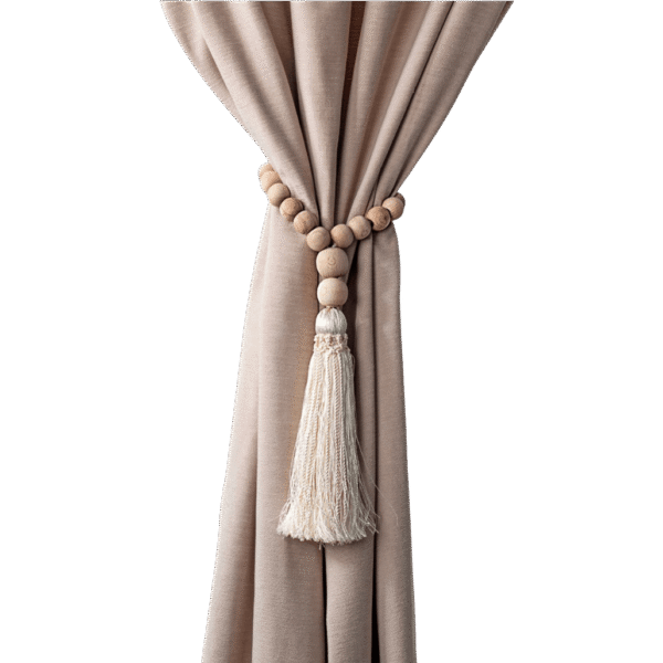 Wooden curtain tieback with a beaded design and beige tassel, hanging on a beige curtain.